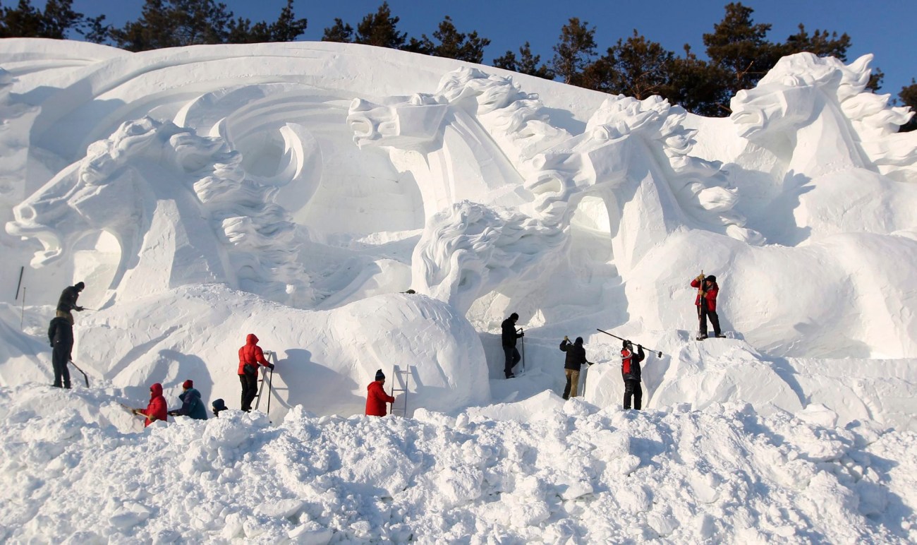 Workers shape a snow sculpture prior to the annual Vasaloppet China Ski Festival at Jingyuetan Park in Changchun